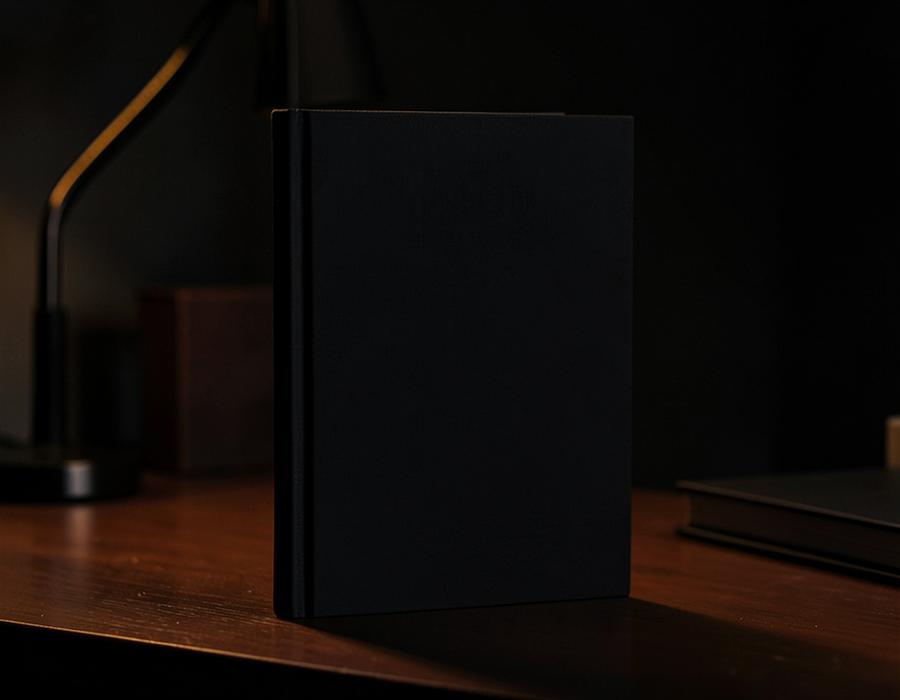 Dark cinematic still life of a book and notes on a desk